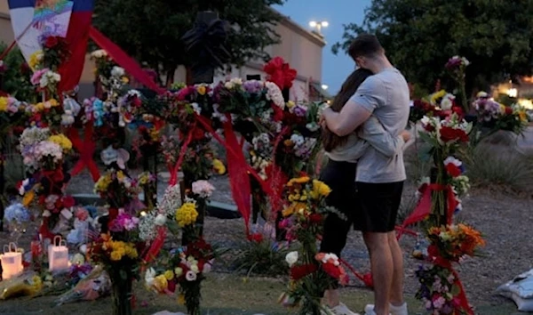 People hug as they visit a memorial to the victims of a mass shooting in Allen, Texas, U.S., May 7, 2023. (AFP