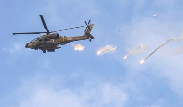 An Israeli Air Force AH-64 Apache attack helicopter releases flares during a raid in Jenin in the occupied West Bank on June 19, 2023. (AFP)