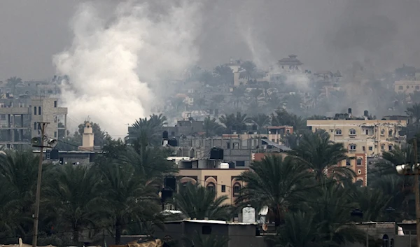 Smoke rises due to Israeli airstrikes above buildings in Khan Younis in the southern Gaza Strip on Dec. 5. (AFP via Getty Images)