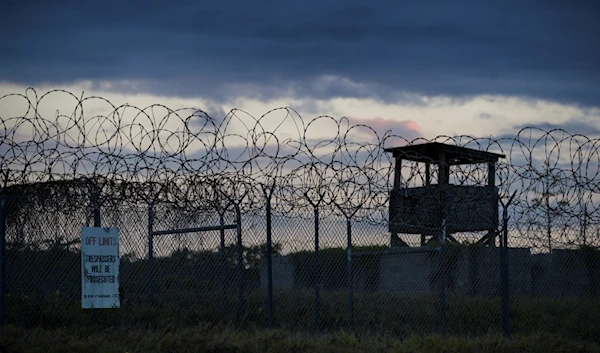 In this photo reviewed by U.S. military officials, the sun sets behind the closed Camp X-Ray detention facility, Wednesday, April 17, 2019, in Guantanamo Bay Naval Base, Cuba (AP Photo/Alex Brandon, File)