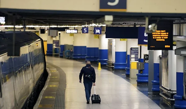 A passenger walks at Euston station during a strike by members of the Rail, Maritime and Transport union (RMT), in a long-running dispute over jobs and pensions, in London, January 3, 2023 (AP).