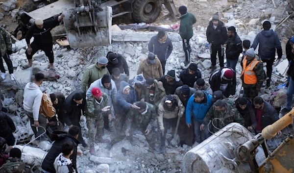 Residents search for victims and survivors amidst the rubble of a collapsed building in the town of Jableh in the province of Latakia, northwest of the capital Damascus, on 8 February 2023 (AFP)