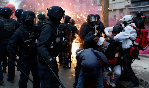 Activists protect themselves against riot police officers during a demonstration against pension changes, Thursday, Jan. 19, 2023 in Paris. (AP)