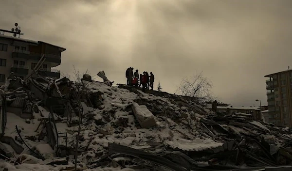 People try to reach people trapped under the debris of a collapsed building in Malatya, Turkiye, Tuesday, Feb. 7, 2023. (AP)