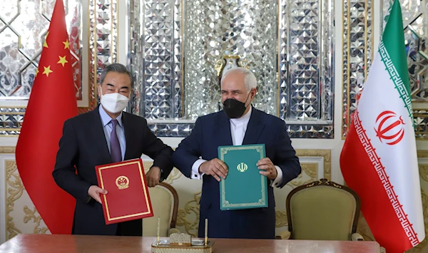 Iran's Foreign Minister Mohammad Javad Zarif and China's Foreign Minister Wang Yi during the signing ceremony of the 25-year cooperation agreement in Iran in March 2021 (Reuters)