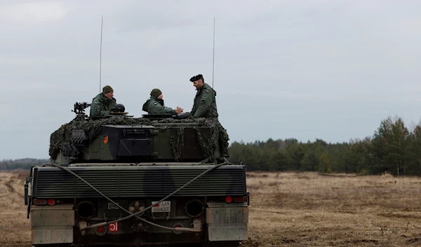 Ukrainian and Polish soldiers sit on top of a Leopard 2 tank during a training at a military base and test range in Swietoszow, Poland, Monday, Feb. 13, 2023 (AP Photo/Michal Dyjuk)