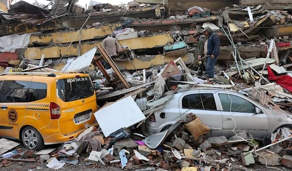 People inspect the damage as rescuers search for survivors in the aftermath of a deadly earthquake in Hatay, Turkey.(REUTERS)