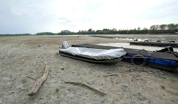 Boats lie on the dried riverbed at a tourist dock along the Po river in Ficarolo, Italy, Thursday, July 28, 2022 (AP).