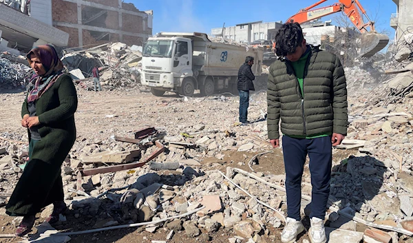 Taha Erdem, 17, right, his mother Zeliha Erdem, left, and father Ali Erdem stand next to the debris from a building where Tahan was trapped after the earthquake of February 6, in Adiyaman, Turkey, February 17, 2023 (AP Photo)