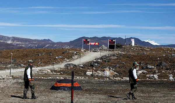 In this Sunday, Oct. 21, 2012, file photo, Indian army soldiers walk along the line of control at the India- China border in Bumla in the northeastern Indian state of Arunachal Pradesh (AP Photo/Anupam Nath, File)