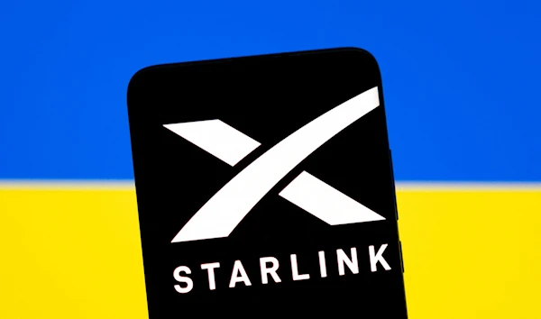 Starlink logo is seen on a smartphone in front of displayed Ukrainian flag in this illustration taken February 27, 2022. (Reuters)