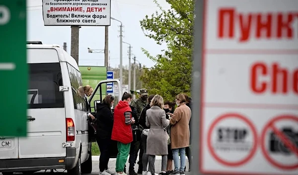 A Transnistrian servicemember checks the passengers of a van entering Transnistria on April 28, 2022.