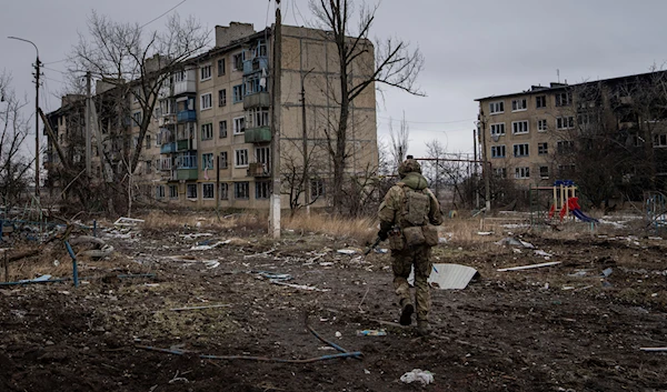 A Ukrainian marine serviceman runs to take a position through the residential blocks in the frontline city of Vugledar, Donetsk region, Saturday, Feb. 25, 2023 (AP Photo/Evgeniy Maloletka)