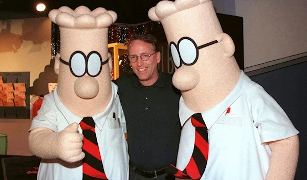 Scott Adams, the creator of "Dilbert", poses with two "Dilbert" characters at a party January 8, 1999 in Pasadena, California. (Reuters)