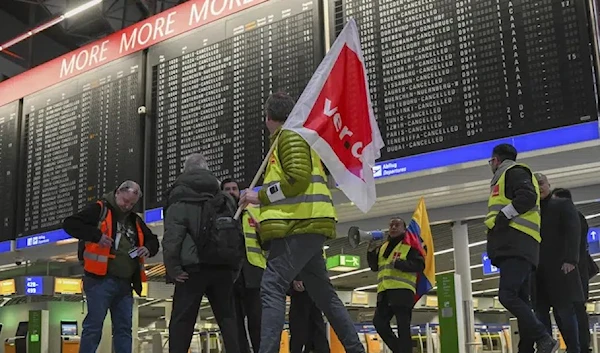 Airport employees in strike vests are on the move in Departure Hall B in Terminal 1 of Frankfurt Airport in Munich, Germany, Friday, Feb. 17, 2023. (AP)