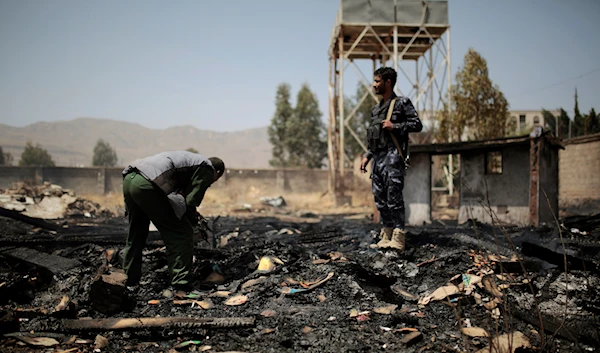 Yemeni police inspect a site of Saudi-led airstrikes targeting two houses in Sanaa, Yemen, March 26, 2022 (AP Photo)