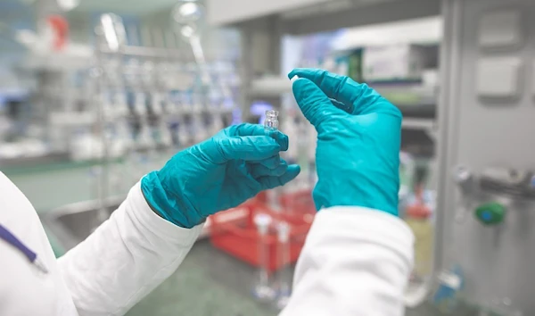 A laboratory assistant working on a vaccine formula (Northwestern)