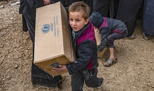 Syrian kid holds a UNICEF aid box. (UNICEF)