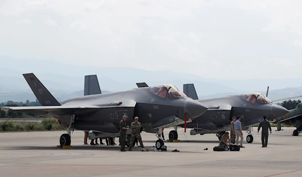 U.S. military personnel work near F-35 fighter jet of the Vermont Air National Guard, parked in the military base at Skopje Airport, North Macedonia, on June 17, 2022 (AP Photo/Boris Grdanoski, File)