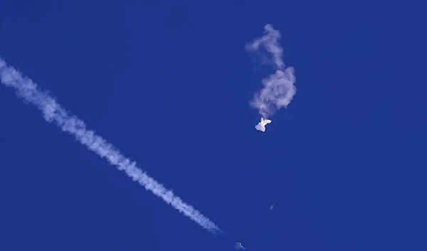 In this photo provided by Chad Fish, the remnants of a large balloon drift above the Atlantic Ocean, just off the coast of South Carolina, with a fighter jet and its contrail seen below it, Feb. 4, 2023. (AP)