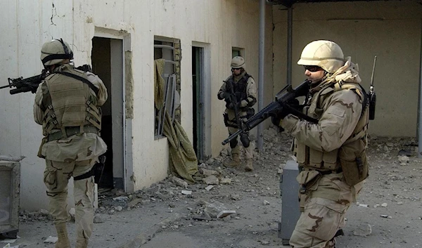 US Navy Chief Petty Officer Ardell Ball raiding a former agricultural building in Fallujah, west of Baghdad, on 18 December 2004 (AFP)