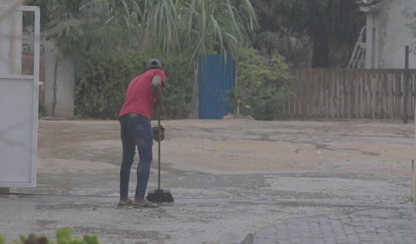 [2/3] A man sweeps off access water as Cyclone Freddy hits areas in Mozambique, Vilankulos, Mozambique, February 24, 2023, in in this screen grab obtained from a social media video. UNICEF Mozambique/223/Alfredo Zuniga/via REUTERS