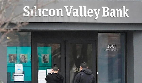 People look at signs posted outside of an entrance to Silicon Valley Bank in Santa Clara, Calif., Friday, March 10, 2023 (AP Photo/Jeff Chiu)