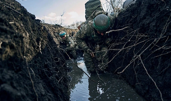 Ukrainian soldiers in a trench under Russian shelling on the frontline close to Bakhmut, Donetsk region, Sunday, March 5, 2023 (AP Photo/Libkos, File)