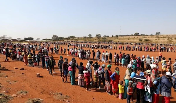 eople stand in a queue to receive food aid at the Itireleng informal settlement, near Laudium suburb in Pretoria, South Africa, May 20, 2020 (Reuters)