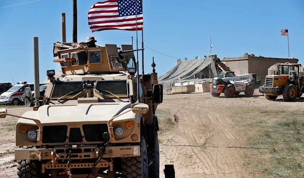 A US soldier sits on an armored vehicle behind a sand barrier at a position near the frontlines in Syria (AP).