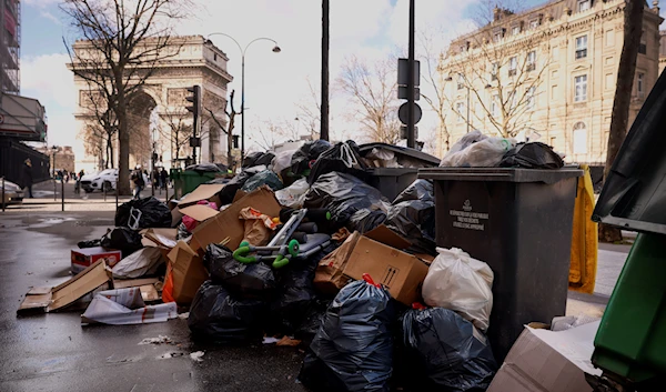 Uncollected garbages are pictured near the Arc de Triomphe in Paris, March 14, 2023 (AP Photo)