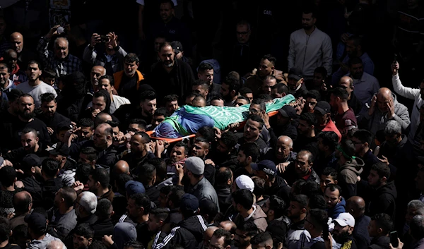 Palestinians carry the body of Abdul Fattah Kharushah, draped in the Hamas flag during his funeral in the West Bank city of Nablus, March 8, 2023 (AP Photo)