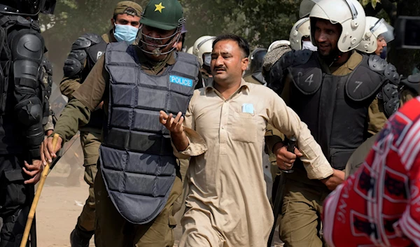 Riot police officers detain a supporter of former Prime Minister Imran Khan during clashes, in Lahore, Pakistan, March 15, 2023 (AP Photo)