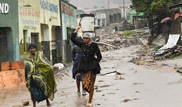 Women walking near the debris in Blantyre, Malawi, on March 14, 2023 (AP)