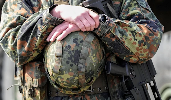 A German soldier holds his helmet during a visit of Governor Hendrick Wuest at the army base Field Marshal Rommel Barracks in Augustdorf, Germany, March 30, 2022 (AP).