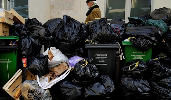 A man walks past uncollected garbages in Paris, March 16, 2023 as sanitation workers are on strike (AP)