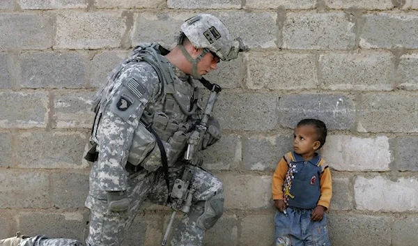 A US soldier with an Iraqi child in Baghdad, 2008. (Mauricio Lima/AFP)