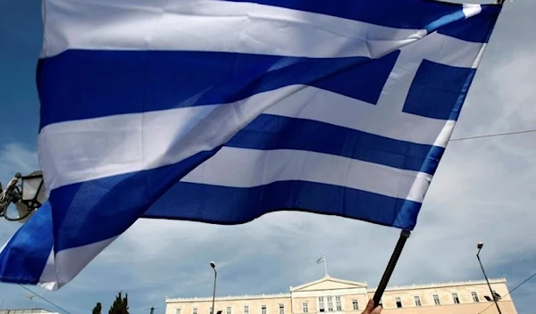 A woman waves a Greek flag in front of parliament during a protest against the government's austerity measures in Athens May 3, 2010. (Reuters)