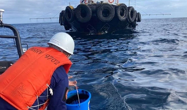 Philippine Coast Guard personnel collect water samples from an oil spill in the waters off Naujan in Oriental Mindoro province after the sinking of a tanker carrying 800,000 litres of industrial fuel oil (AP).