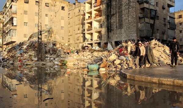 People walk past rubble of damaged buildings, in the aftermath of the earthquake, in Aleppo, Syria February 7, 2023. (Reuters)