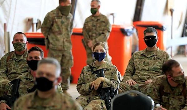 U.S. soldiers wearing protective masks are seen during a handover ceremony of Taji military base from US-led coalition troops to Iraqi security forces, in the base north of Baghdad, Iraq August 23, 2020. (Reuters)