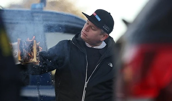 Danish-Swedish politician burning a copy of the Quran in Denmark in January 2023 (Reuters)