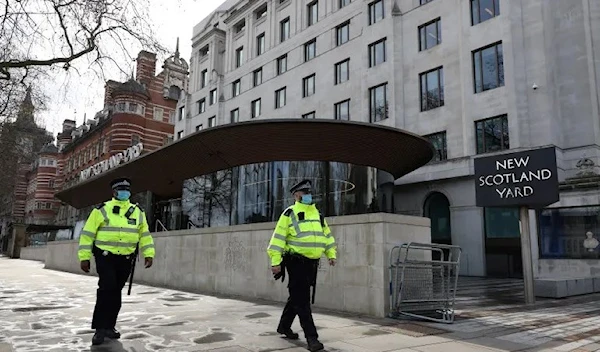 Police officers walk past New Scotland Yard, the headquarters of the Metropolitan Police Service in London, UK on March 15, 2021. (AFP)