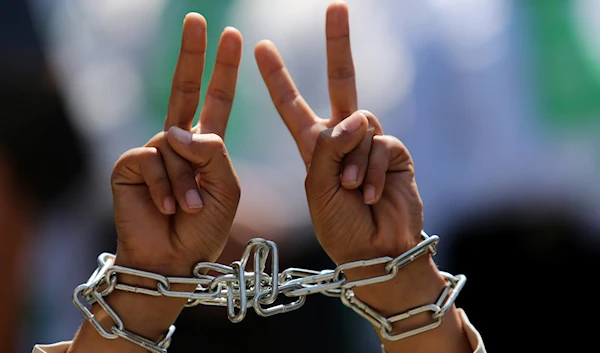 Palestinians chain themselves in solidarity with Palestinian prisoners on hunger strike at Israeli jails, while holding a rally in the Jebaliya refugee camp, the northern Gaza Strip, Friday, May 9, 2014. (AP)