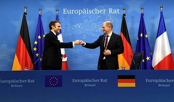 France's President Emmanuel Macron and Germany's Chancellor Olaf Scholz bump fists after holding a joint news conference at the conclusion of an EU Summit in Brussels, Belgium December 17, 2021. (Reuters)