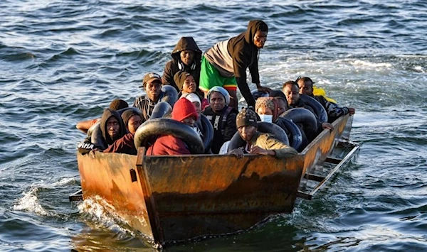 Migrants from sub-Saharan Africa sit in a makeshift boat off the coast of Tunisia's city of Sfax on October 4, 2022. (AFP)