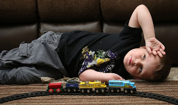 A child plays with his trains (Reuters)