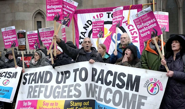 Stand Up To Racism activists outside the High Court of Justice for England and Wales in London, December 19, 2022. (AP)