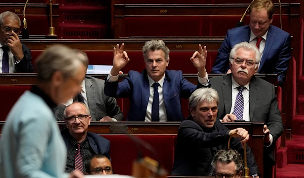 French lawmaker Fabien Roussel, of the communist party, center, reacts during the speech of French Prime Minister Elisabeth Borne at the National Assembly in Paris, Monday, March 20, 2023 (AP).