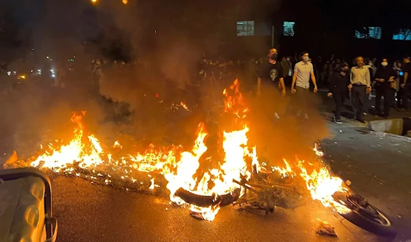 A police motorcycle burns during a protest over the death of Mahsa Amini, September 19 2022 (AP).